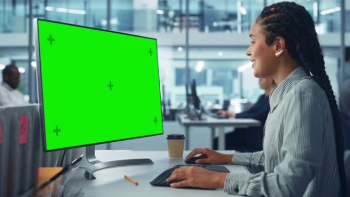 公司办公室: 黑人女性it技术人员使用带有绿色色度键屏幕的台式计算机。微笑的创意软件工程师从事电子商