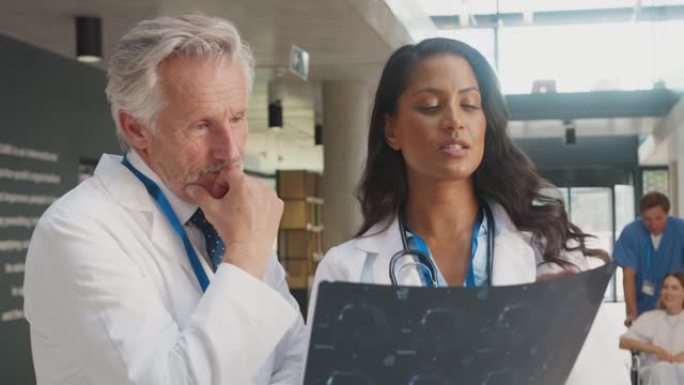 穿着白大褂的医生与医院女同事讨论病人扫描的特写