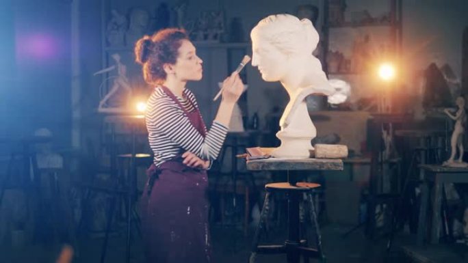 女雕塑家正在刷石膏半身像