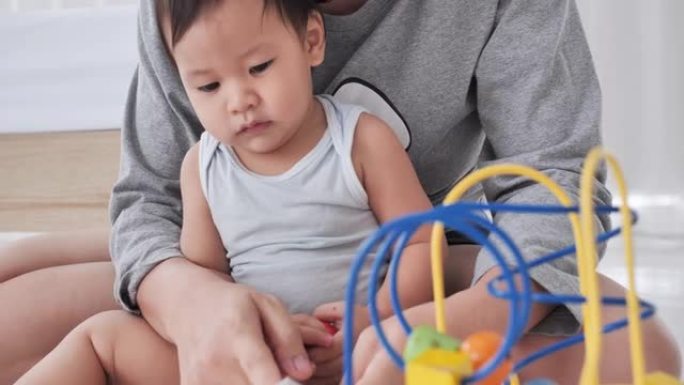 亚洲母亲家庭与男婴年龄10个月阅读故事与她的小男孩儿子呆在家里预防冠状病毒或Covid-19.Sou