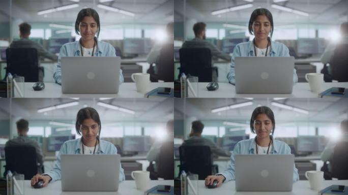 多元化的办公室: 美丽的印度IT程序员在台式计算机上工作的肖像，微笑着，亲切地看着相机。女性软件工程