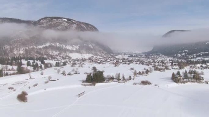 空中: 在布希尼 (Bohinj) 附近风景如画的乡村上空飞行，积雪覆盖。