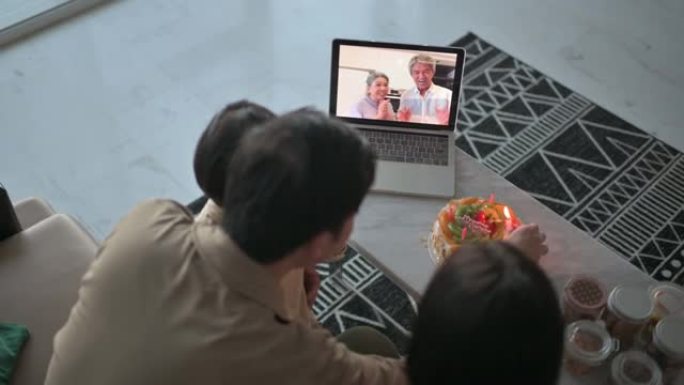 祖父母，亚洲华人家庭在客厅为儿子庆祝生日而唱歌和拍手的高视角视频