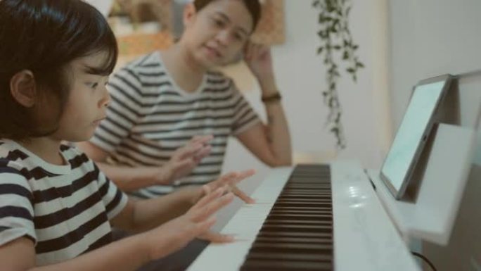 亚洲家庭与老师一起玩钢琴在线学习。