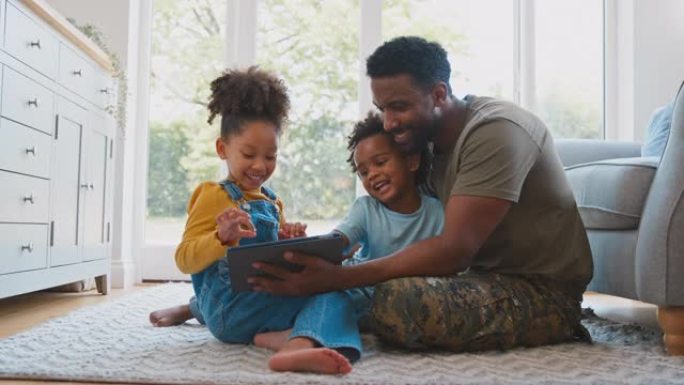 军装父亲回家休假，孩子们坐在地毯上玩平板电脑——慢镜头拍摄