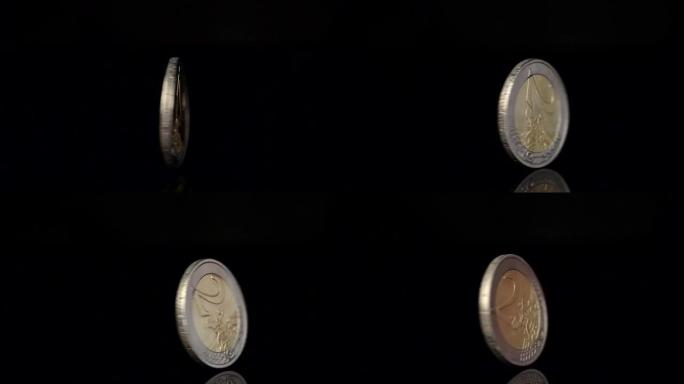 黑色背景上旋转的两个欧元硬币。欧元货币下跌或上涨。特写慢动作镜头