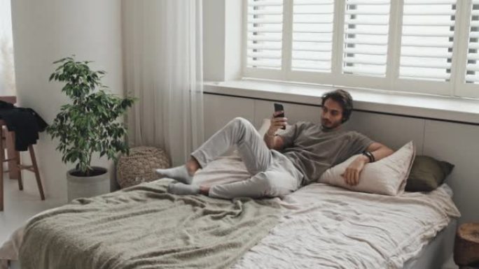 男子在床上使用智能手机