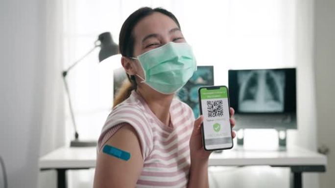 亚洲妇女在新型冠状病毒肺炎大流行期间在海关的手机上展示数字疫苗护照应用程序