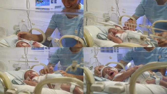 开朗的NICU护士非常亲切地试图让孵化器中的婴儿平静下来