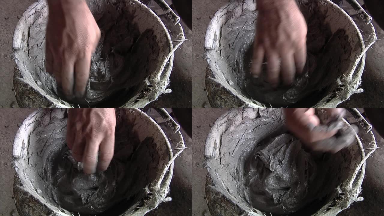 在贝尔工厂用泥土在水桶上工作的人。特写。