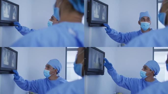 混血男外科医生穿着防护服，在屏幕上展示x射线