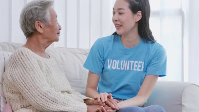 亚洲年轻女性肖像志愿者牵着老年女性祖母病人的手帮助表达同理心鼓励在家探望。志愿服务