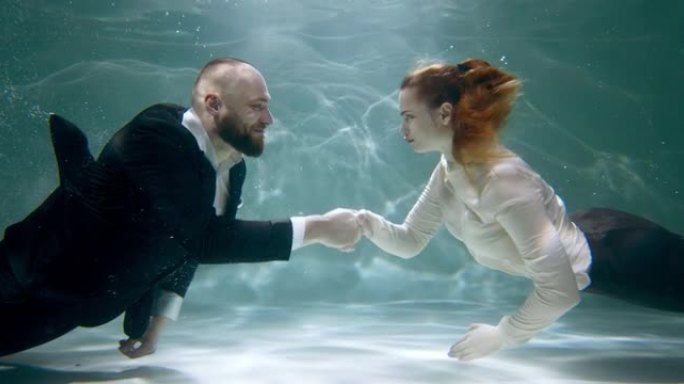协议概念。快乐积极的商业男人和女人握手微笑慢动作的水下电影