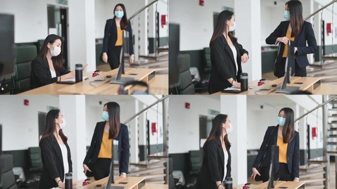 2位亚裔华裔女同事在办公室用新的握手方式互相问候