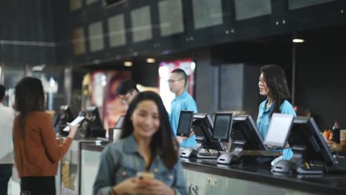 亚洲华人女顾客从电影院电影院售票柜台购买电影票