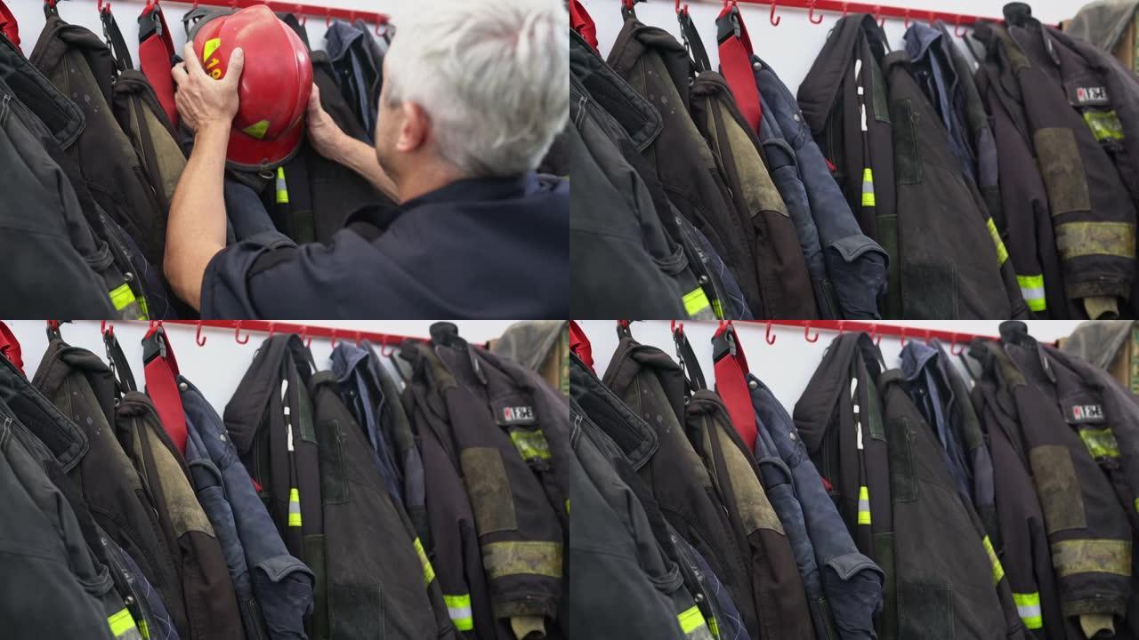 成熟的第一响应者在消防局中抓住红色头盔