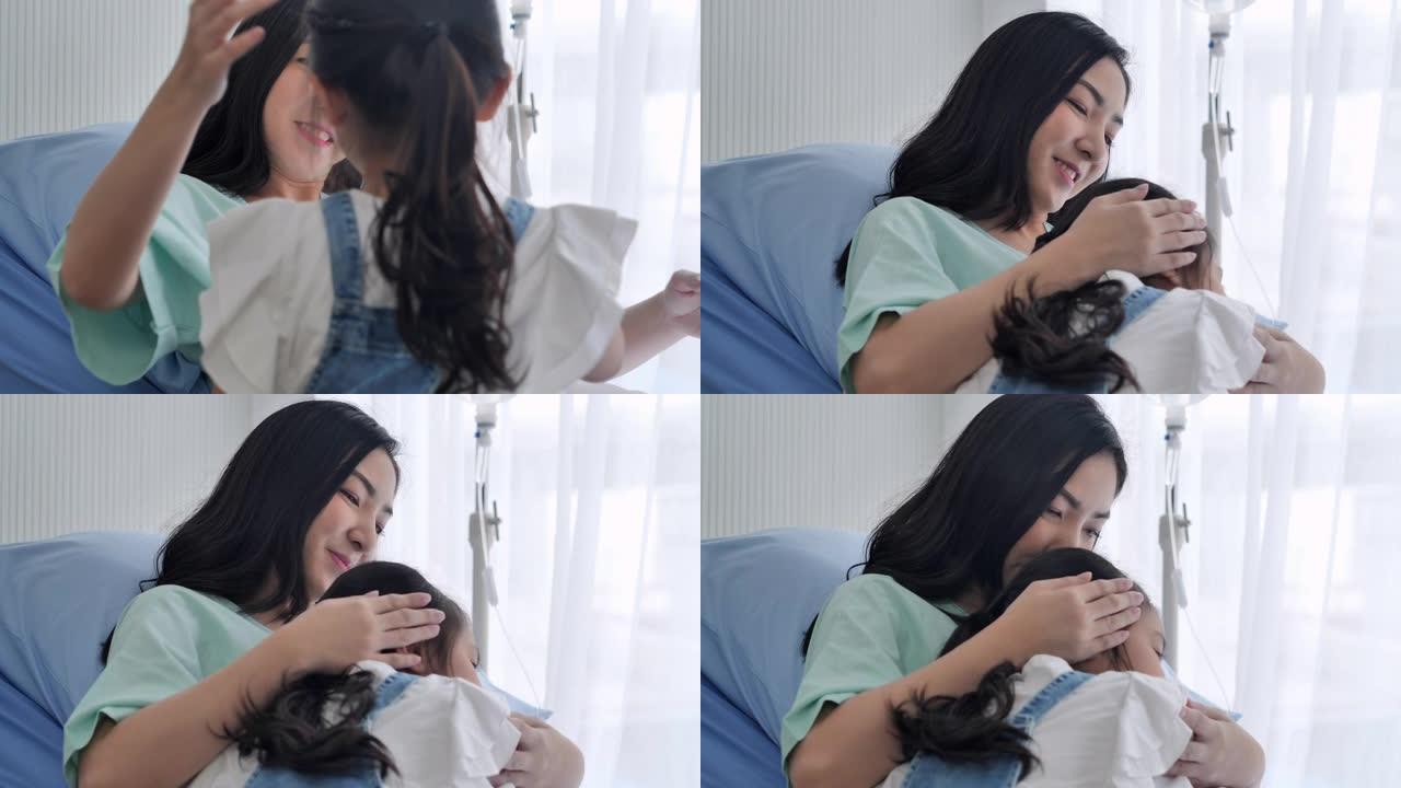 6-7岁的亚洲年轻女孩在医院的病床上与母亲拥抱。母亲和小女孩一起在诊所度过时光。单亲家庭