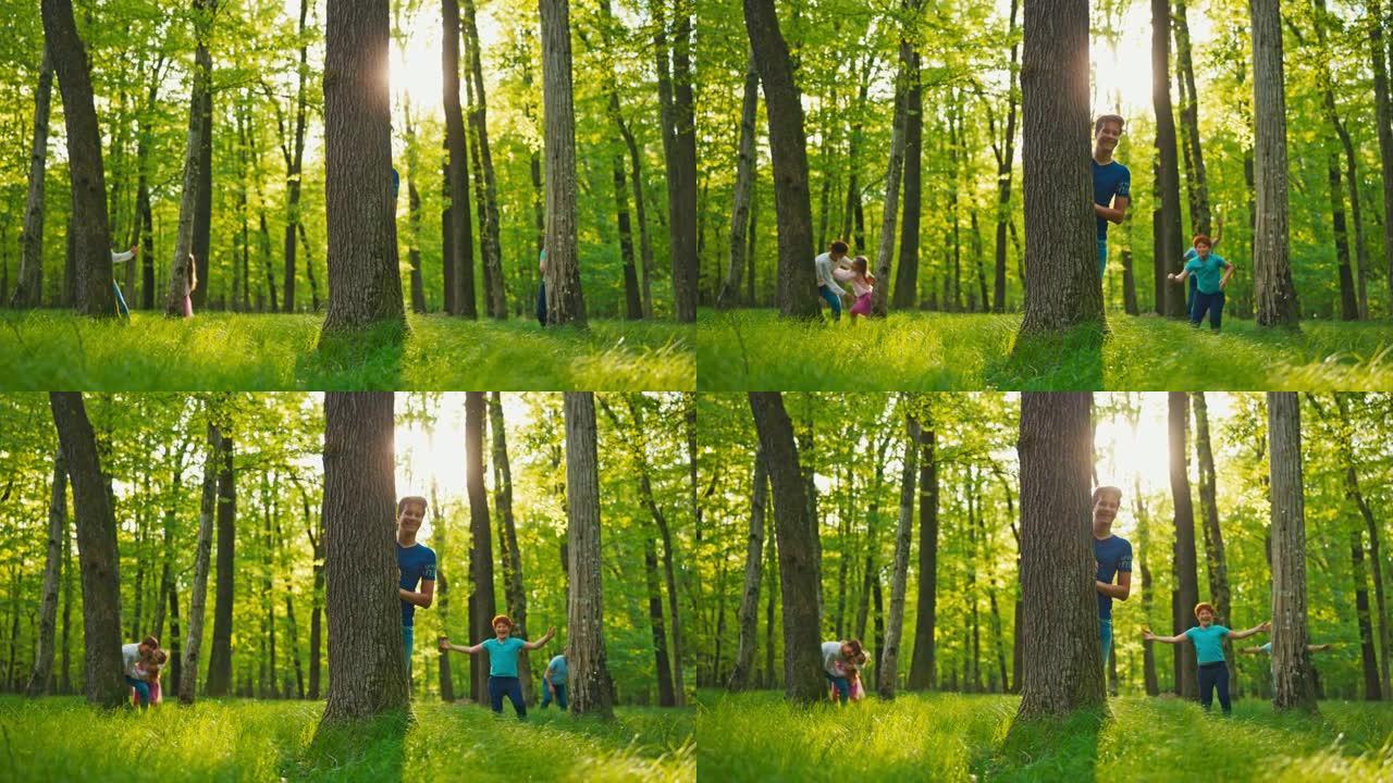 SLO MO肖像，一个家庭躲在绿色森林中的树木后面