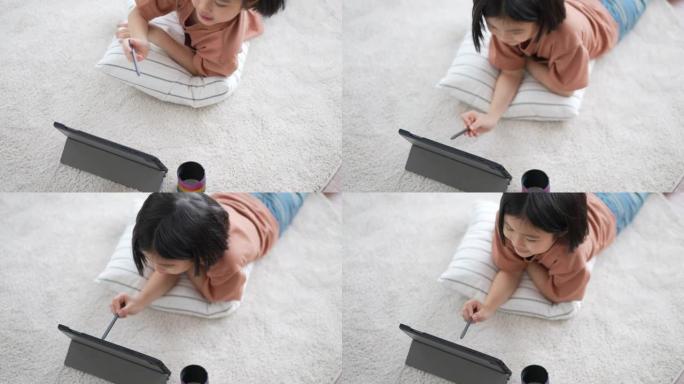 小女孩在家客厅用数字铅笔在数字平板电脑上画画
