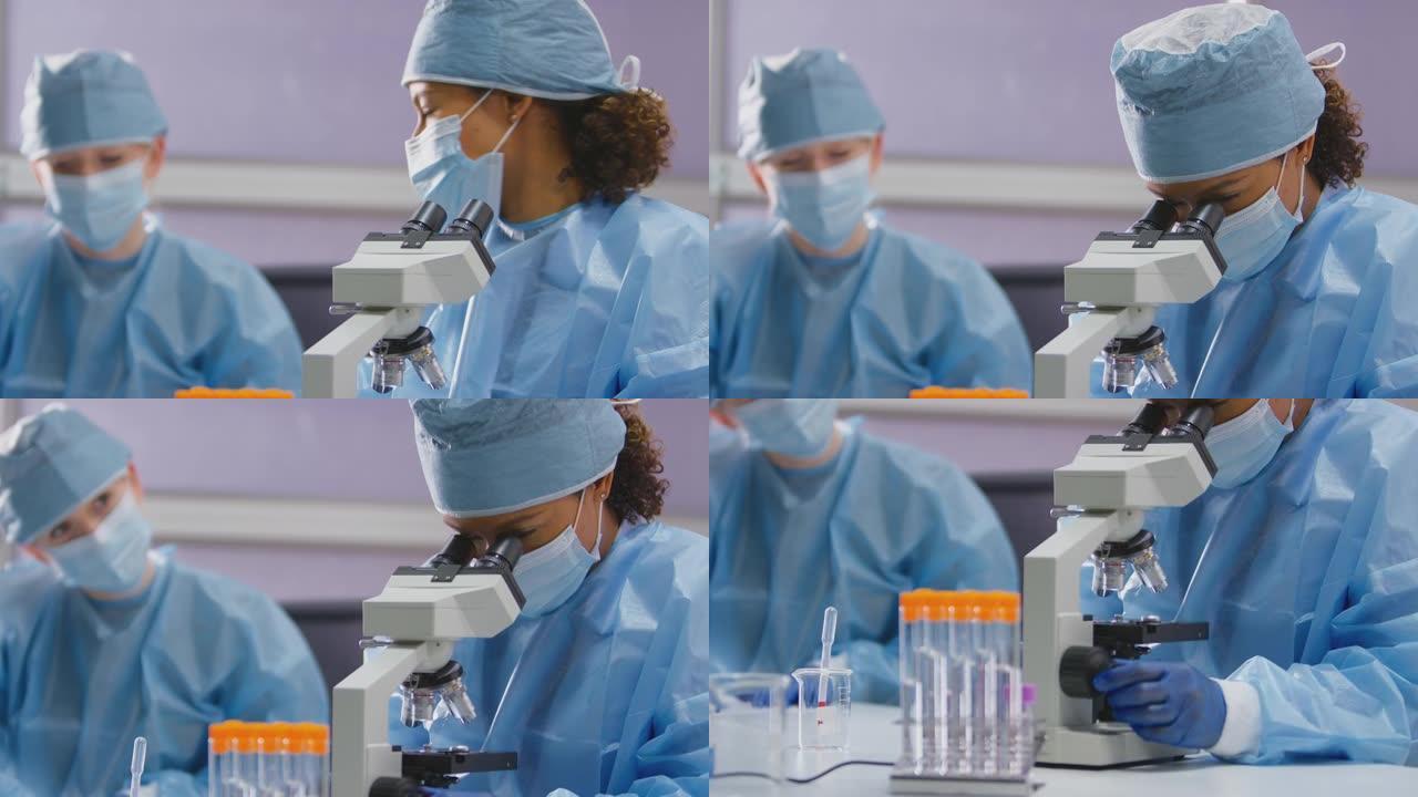 女实验室工作人员穿着个人防护用品在实验室分析样品并记录测试结果