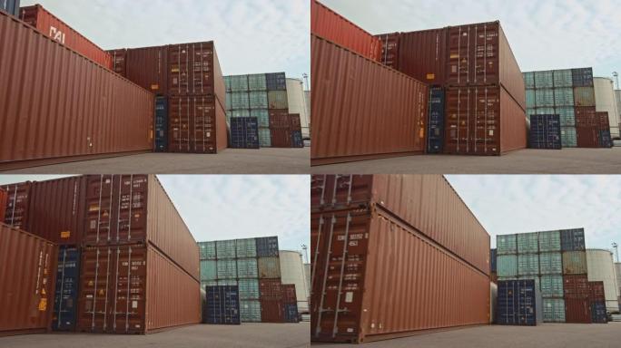 船厂物流运营中心的工业码头位置的低角度广角概览镜头，其中装有红色和蓝色钢制集装箱。白天多云的户外镜头