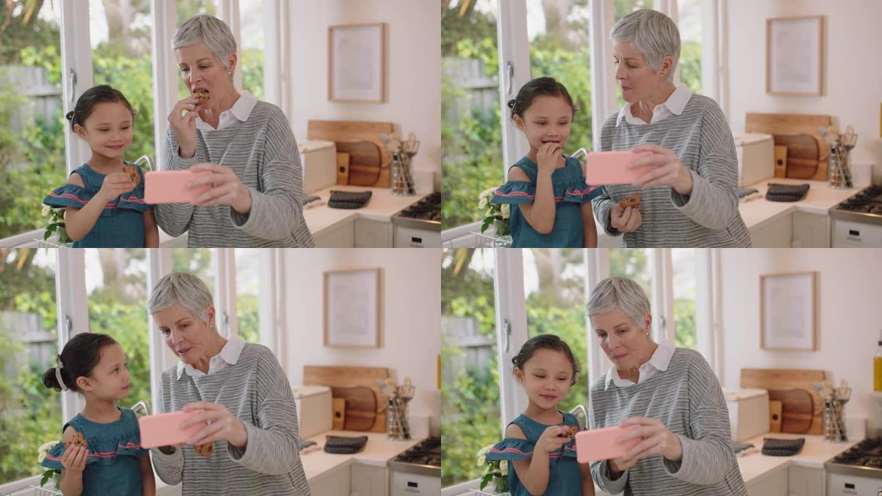 祖母和孩子使用智能手机进行视频聊天小女孩分享假期周末显示饼干奶奶喜欢在家和孙女在手机上聊天