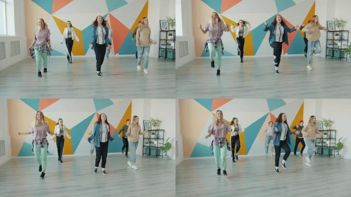 快乐的女孩和男孩在舞蹈工作室跳舞，学习当代动作
