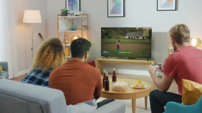 在客厅里，三个朋友使用控制器玩视频游戏。电视屏幕显示真正的3D射击游戏，与街机在线多人战斗皇家游戏。