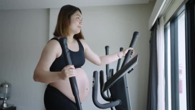 孕妇在健身室锻炼，使用椭圆形身体健康