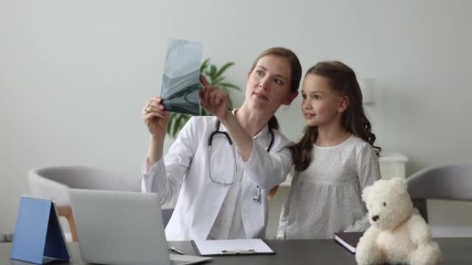 儿科医生向可爱的小女孩展示x射线和放射学结果