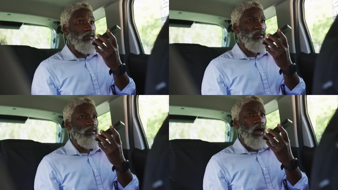 非裔美国高级男子坐在车里用智能手机聊天