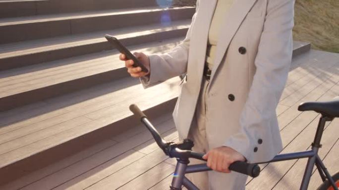 骑自行车在户外智能手机上滚动的女人
