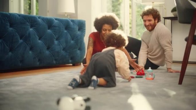 爱的混血家庭在客厅地板上在家和可爱的男婴一起玩玩具。开朗的父母养育孩子。童年、新生活、为人父母的概念