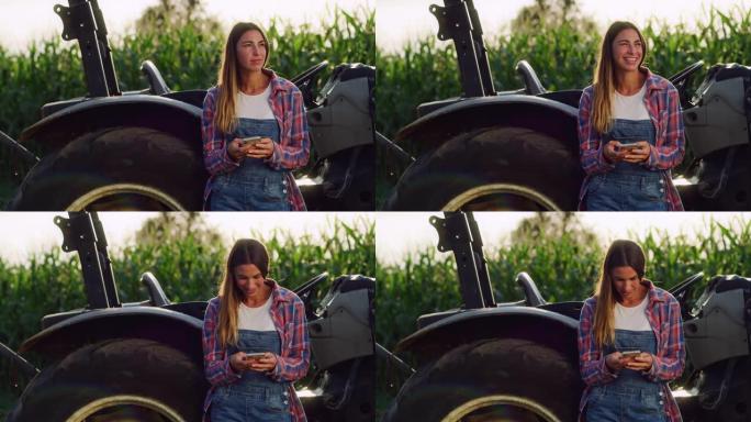 在一片绿色的玉米地里，一名年轻女子在拖拉机旁使用智能手机。女农民在保持联系和使用互联网改善她的业务时