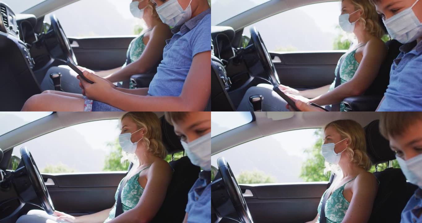 Cauciasian母子坐在汽车上，戴着口罩