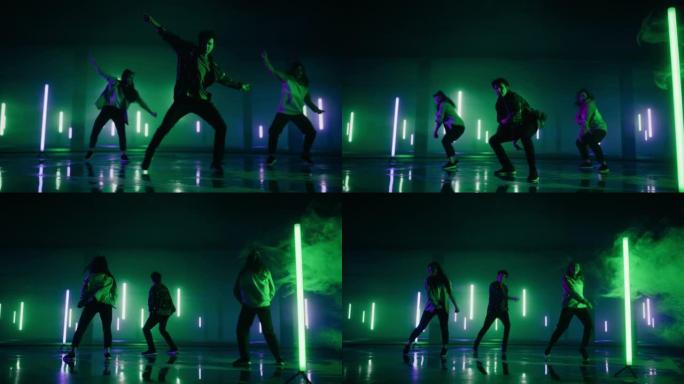 由三个不同的时尚专业舞者组成的小组，在虚拟制作工作室环境中表演嘻哈舞蹈套路，配有霓虹灯的3D地下车库