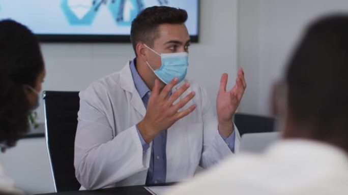 混血男医生戴着口罩在会议室做手势