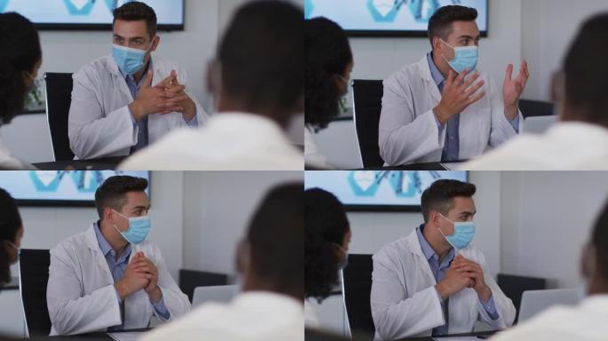 混血男医生戴着口罩在会议室做手势