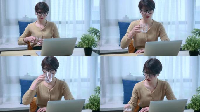 商业亚洲女性饮水杯和笔记本电脑工作