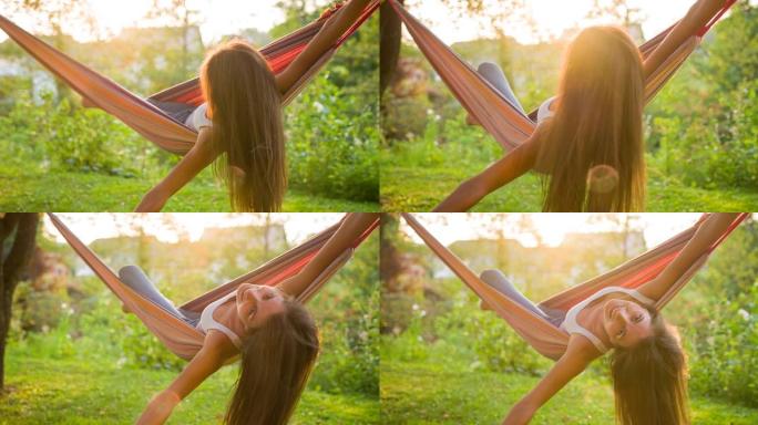 快乐的年轻女子在暑假在后院的吊床上玩得开心