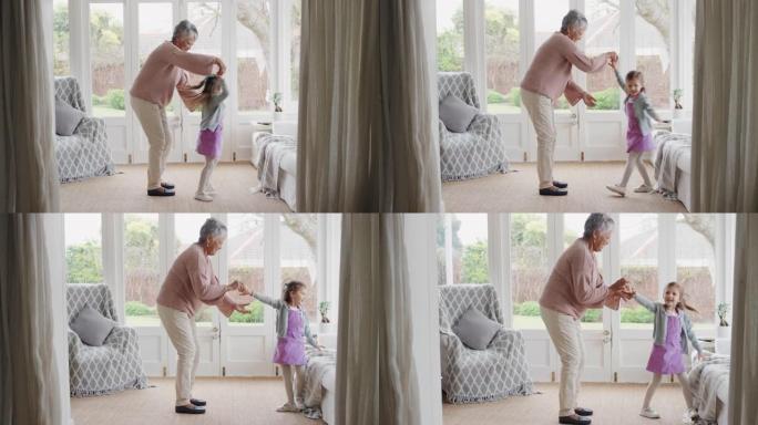 可爱的小女孩和祖母跳舞有趣的奶奶和孙女一起跳舞，在家庆祝家庭周末4k