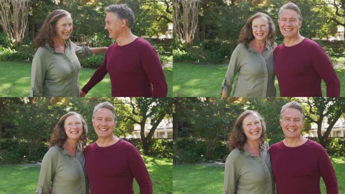 站在花园里拥抱和微笑的快乐高级高加索夫妇的肖像