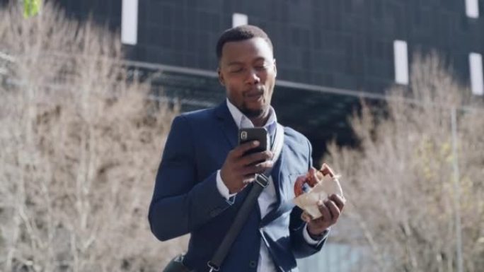 快乐的生意离开工作大楼吃饭，并在他的手机上滚动社交媒体。年轻的非洲裔美国员工在城市里户外散步，享受三