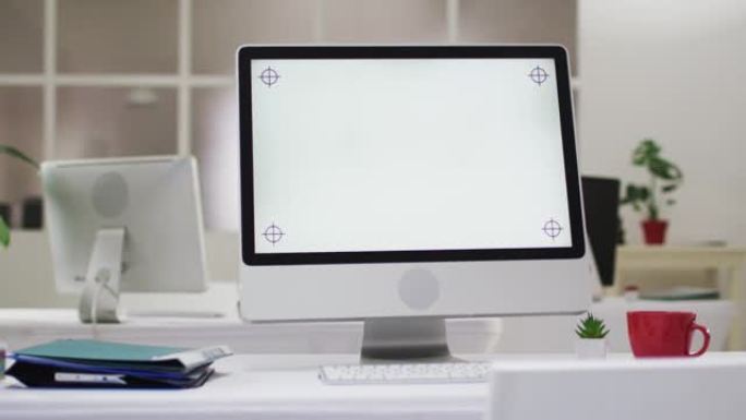 办公室办公桌上的电脑屏幕和办公用品视图