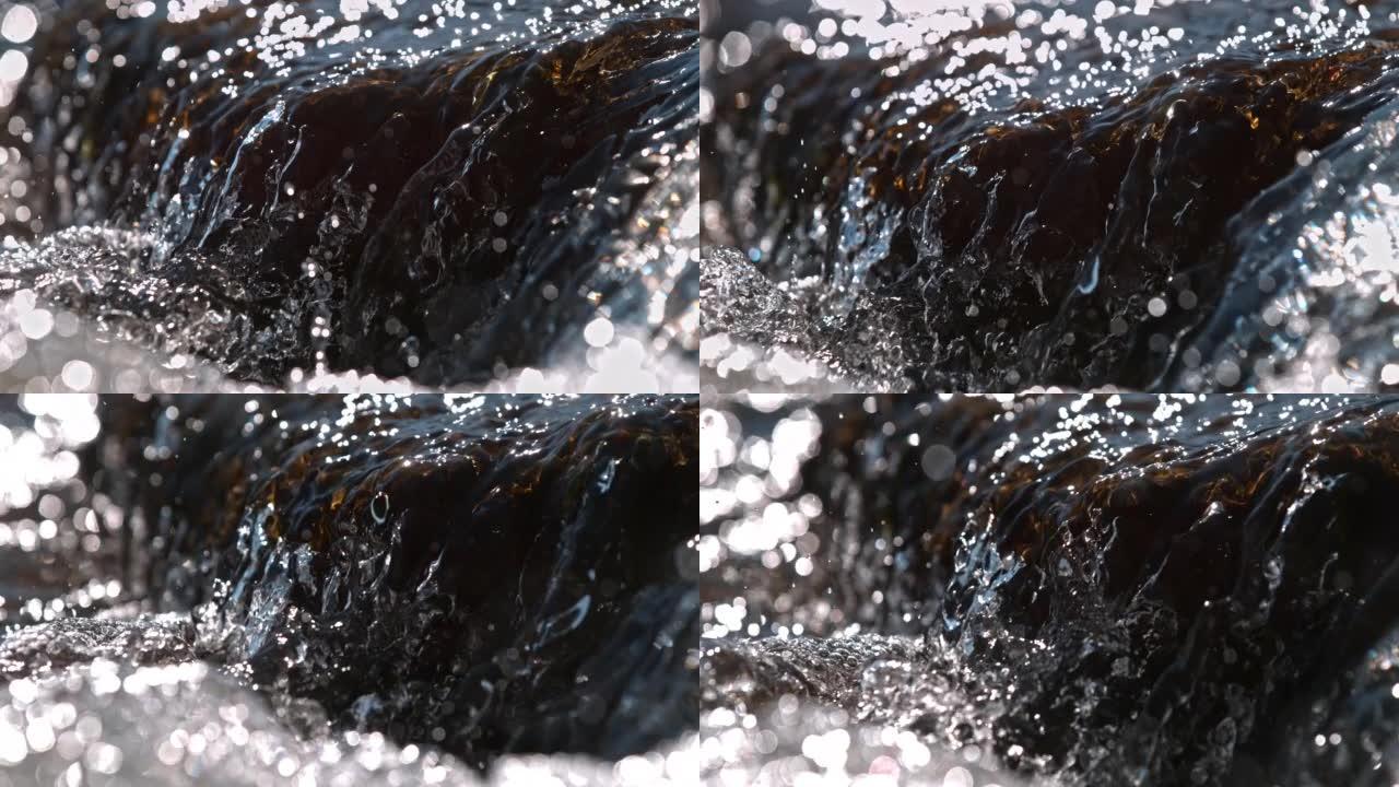 超级SLO MO特写镜头水流下棕色的石头，河里的小瀑布，从侧面看