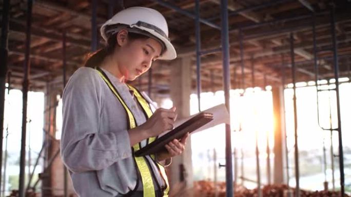 在建筑工地使用数字平板电脑检查结构的女工程师