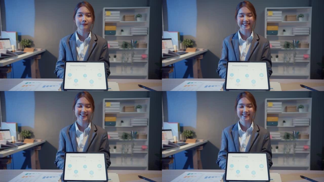 行政女商人的肖像智能休闲装看着相机，微笑着，在现代办公室工作场所之夜快乐。年轻的亚洲女士在家里的视频