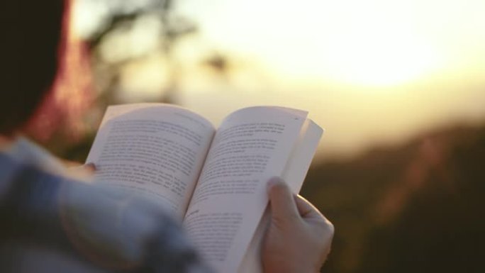 女人在户外放松，在日落的大自然中看书