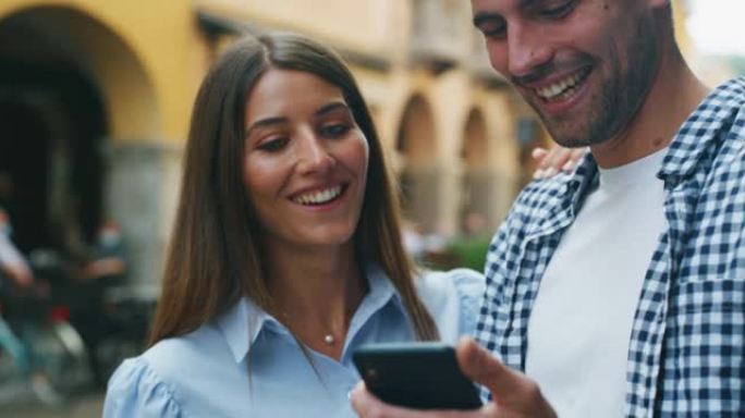 年轻快乐浪漫的游客夫妇使用智能手机上的应用程序，在假日旅行期间在老城中心观光时，一起检查新的游览地点