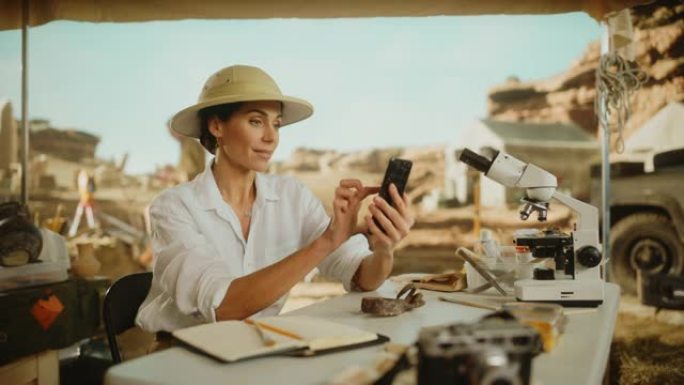 考古挖掘地点: 伟大的女性考古学家进行研究，使用智能手机在互联网社交媒体上发布化石遗骸，古代文明文化